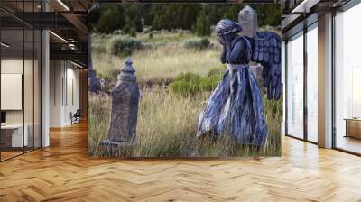 girl wearing an angel costume in an old grave yard Wall mural