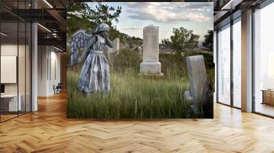 Girl wearing an angel costume in an old grave yard Wall mural