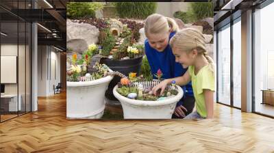 Two young girls helping to make fairy garden in a flower pot Wall mural