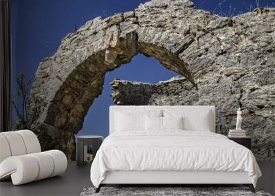 Ruins of the ancient city of Sidima, Turkey, a wall with a partially preserved arch against a blue sky Wall mural