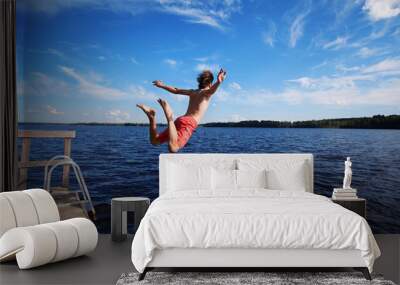 young man jumping into water Wall mural