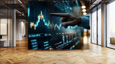 Person analyzing stock market data on a digital screen in a modern financial setting, pointing at a fluctuating graph. Wall mural