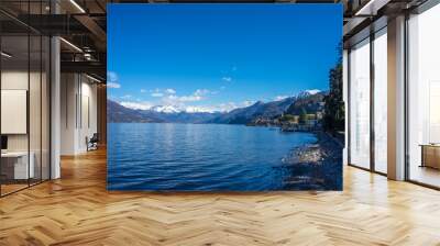 Italy, Bellagio, Lake Como, a large body of water with a mountain in the background Wall mural