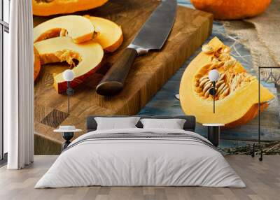 Closeup slices of chopped ripe pumpkin on a wooden cutting board Wall mural