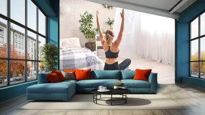 Woman doing exercise on special simulator balancer. blonde sportswear. Wall mural