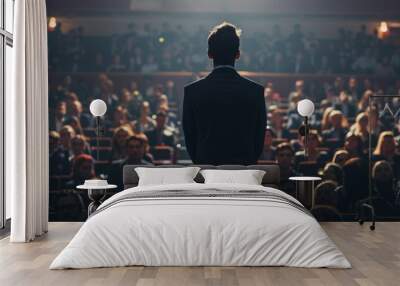 A man in business attire stands on stage facing an audience of many people who have come to listen and learn from him Generative AI Wall mural