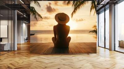 A woman sitting on a wooden deck, looking at the ocean and palm trees in front of her, with the sunset light illuminating the scene Generative AI Wall mural