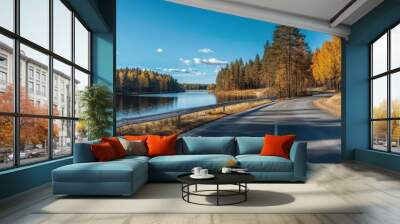 Panoramic photograph of an autumn road in Finland, with a forest and lake, a white guardrail on the side, and a blue sky on a sunny day Generative AI Wall mural