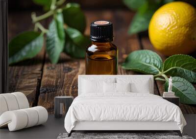 Bottle of bergamot essential oil standing on a rustic wooden surface surrounded by fresh bergamot fruit and leaves Wall mural