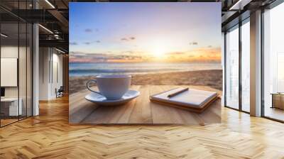 Coffee cup on wood table at sunset or sunrise beach Wall mural