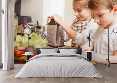 Small boy with his sister preparing food together Wall mural