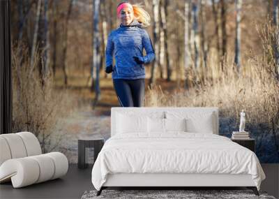 Young girl running in the park in early winter Wall mural