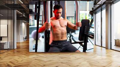 A strong Asian man is exercising to build muscle.. Wall mural