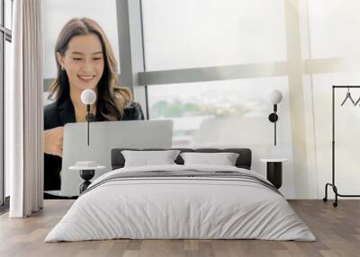 An Asian business executive inspects the work of a female employee at her laptop. Talk with smiling faces and have fun and relax. at the office of the company web banner with copy space on right Wall mural