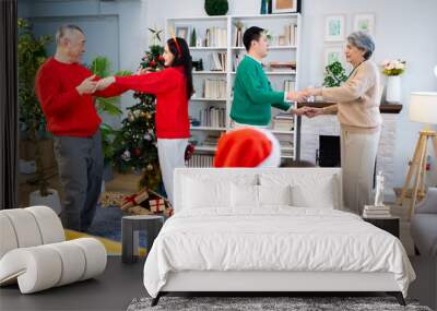 Asian family on Christmas Day. Everyone is happy together in a Christmas themed room filled with presents and orange lights. Wall mural