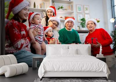 Asian family on Christmas Day. Everyone is happy together in a Christmas themed room filled with presents and orange lights. Wall mural