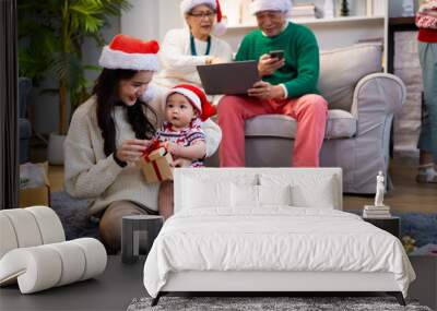 Asian family on Christmas Day. Everyone is happy together in a Christmas themed room filled with presents and orange lights. Wall mural