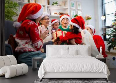 Asian family on Christmas Day. Everyone is happy together in a Christmas themed room filled with presents and orange lights. Wall mural