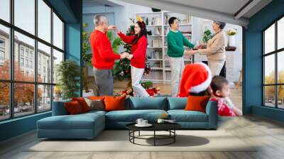 Asian family on Christmas Day. Everyone is happy together in a Christmas themed room filled with presents and orange lights. Wall mural