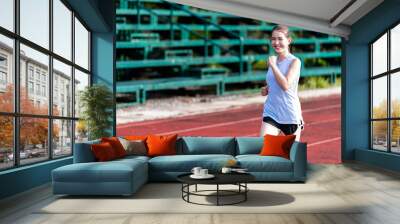 Asian women are jogging in the morning at the stadium to keep fit and healthy. Wall mural