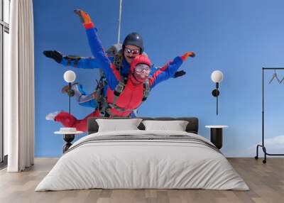 Skydiving. Tandem jump. A strong man and a young woman are falling in the sky. Wall mural