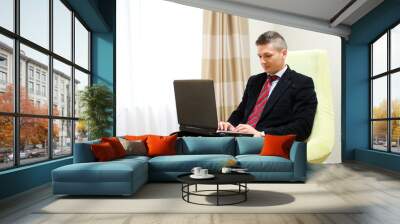 Young business man working at laptop Wall mural