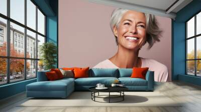 Charming mature 50s woman with gray hair smiling and looking aside isolated on plain pink background. Healthy lifestyle concept Wall mural