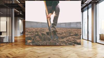 The man is digging the soil ground on his country house Wall mural