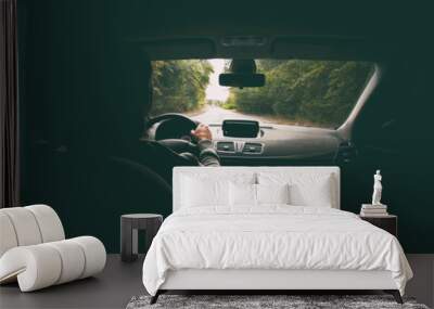 The young man driving the modern car on asphalt road Wall mural