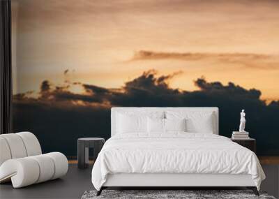 A panoramic view of a stunning dramatic sunset over the ocean, evening on the Maldives, tropical warm sunlight around dark silhouettes of clouds, a water lever at the bottom Wall mural