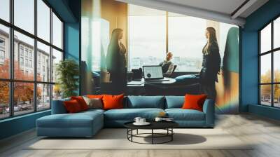 Boardroom of contemporary luxury office high-rise during a business meeting with silhouettes of two colleagues in a defocused background and selective focus on a laptop with a diagram in a foreground Wall mural