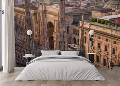 Vertical: Rooftop view of cathedral spires & sculptures, Galleria Vittorio Emanuele II, and distant modern buildings at sunset from Duomo di Milano. Wall mural