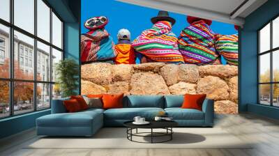 Panoramic photograph of Quechua indigenous women in traditional clothing with a boy sitting on an ancient Inca wall in Chinchero, Cusco Province, Peru. Wall mural