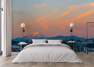 The majestic snowcapped Andes peak of the Cayambe volcano illuminated at sunset with the cityscape of Quito, Ecuador. Wall mural