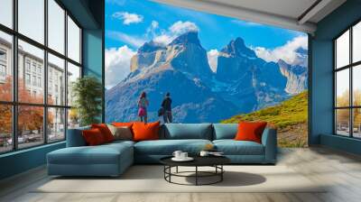 Two tourist, a man and a woman, looking upon a viewpoint of the Andes peaks of Cuernos del Paine, Torres del Paine national park, Puerto Natales, Patagonia, Chile. Wall mural