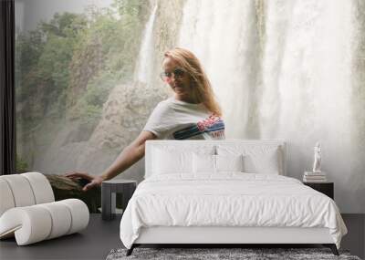 The girl standing near the waterfall Wall mural