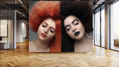 Portrait of two royoung beautiful girls, redhead and brunette womans with clean skin, half of their hair smooth other half curly stranded Wall mural