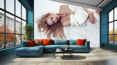 sexy woman with blond hair in white shirt lying on bed Wall mural