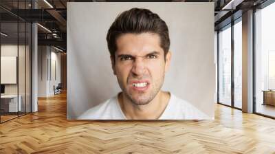 Portrait of a young handsome man with an angry face expression with furious eyes  Wall mural