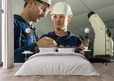 Workers work with cables for EV charging plug and discuss ways for soldering wires. Electricians make charger for charging car in workshop Wall mural