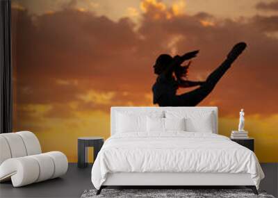 Silhouette of happy children jumping playing at sunset time Wall mural