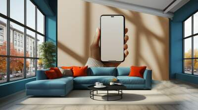 Hand Holding a Smartphone with Blank Screen Indoors Wall mural