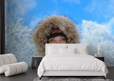 Caucasian young girl with blue eyes looking at camera on snowy background Wall mural