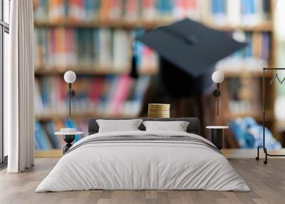 A student searching for scholarships to reduce the need for loans, borrowing money for education, person with degree hap in library backdrop Wall mural