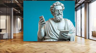 Ancient old Greek God statue with curly hair, smiling, reading text message on modern smartphone, on pastel blue background Wall mural