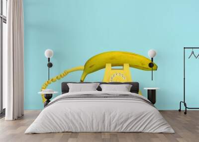 Creative idea layout fresh banana with yellow retro telephone on bluish background.  Fruit minimal concept. Wall mural