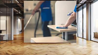 Cleaning an office table.Other cleaners clean in the background Wall mural