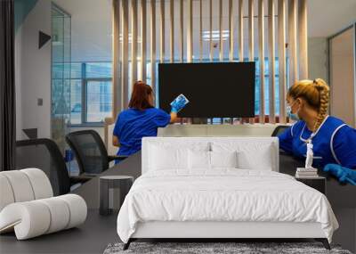 Two cleaners with masks on their faces are cleaning the office photo Wall mural