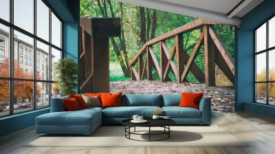 Wooden bridge over the river that is in woods Wall mural