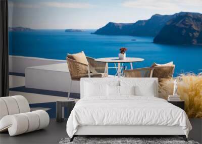 White architecture in Santorini island, Greece. Two chairs on the terrace with sea view. Wall mural